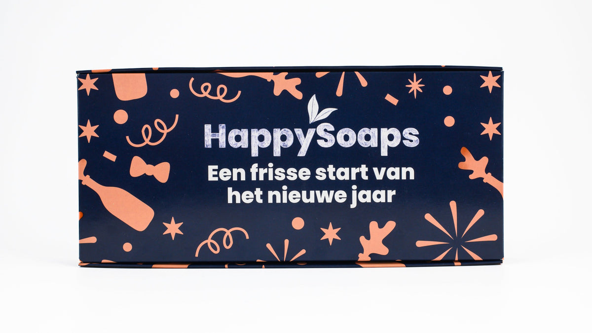 Gesloten Nieuwjaarscadeau Giftbox in donkerblauw met een perzikkleurige print van confetti, strikjes en vuurwerk en de tekst Een frisse start van het nieuwe jaar